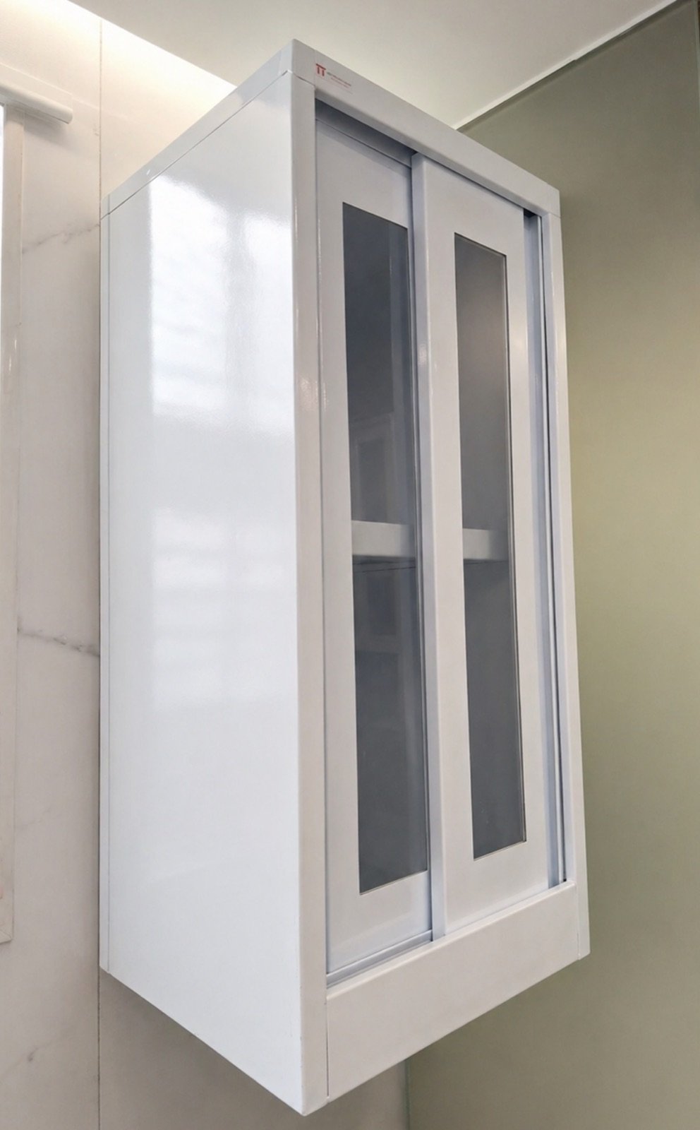 Wall-mounted white steel cabinet with sliding glass doors
